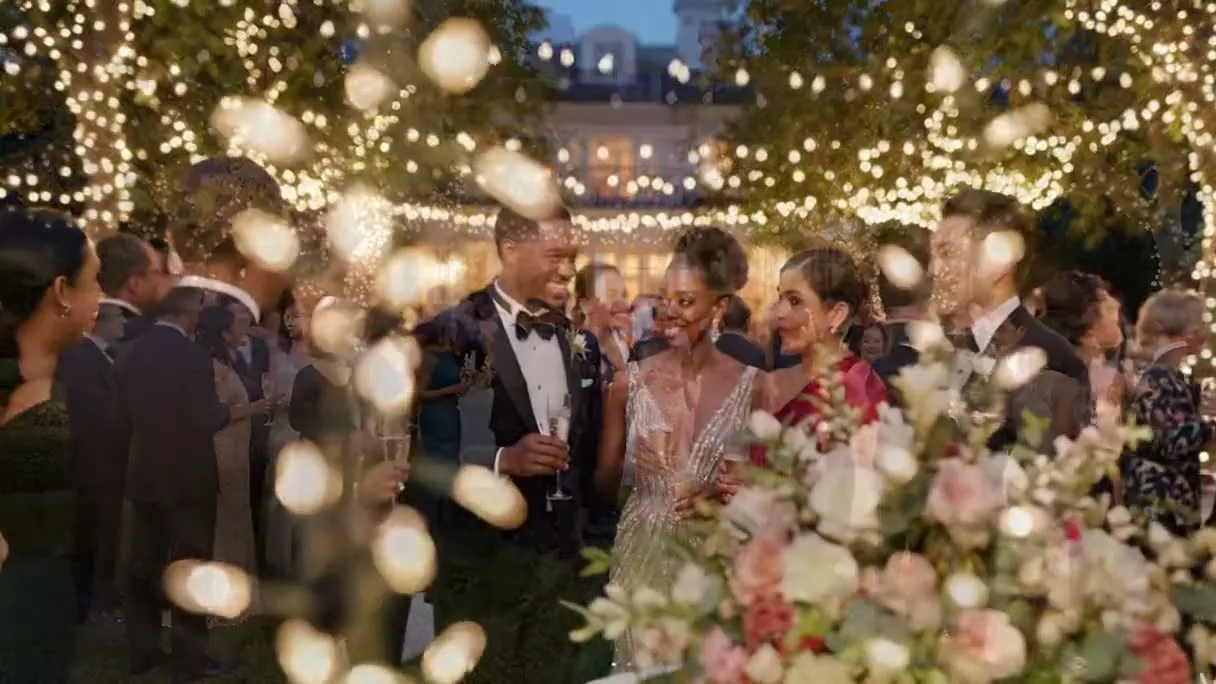 A bride and groom with their guests at an outdoor evening reception